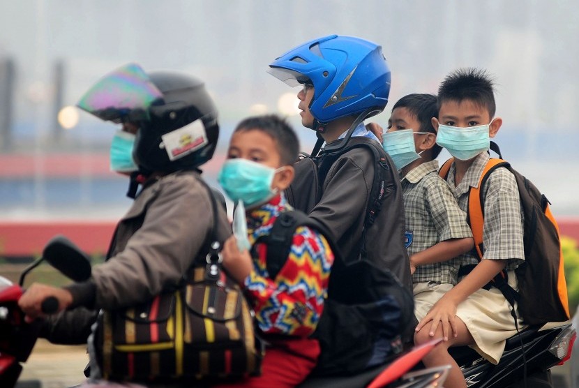  Sejumlah pelajar sekolah dasar menggunakan masker saat melintasi di Jalan Ahmad Yani, Pontianak, Kalimantan Barat, Kamis (10/9).