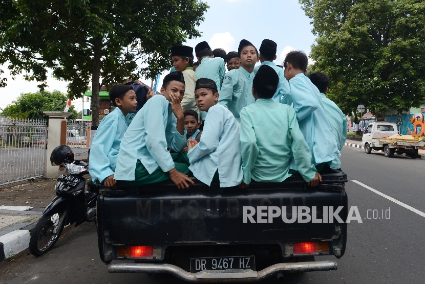 Sejumlah pelajar turun dari mobil bak di depan Kantor Gubernuran untuk menonton MTQ Nasional ke XXVI yang diadakan di Nusa Tenggara Barat, Ahad (31/7
