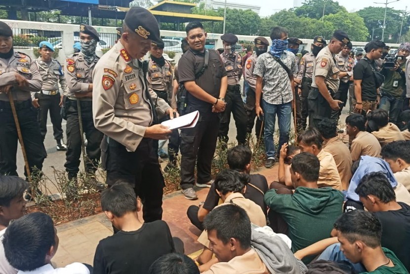 Sejumlah pelajar yang menggelar aksi di depan Kompleks Parlemen RI  diceramahi oleh personel kepolisian. Rabu (25/9). 