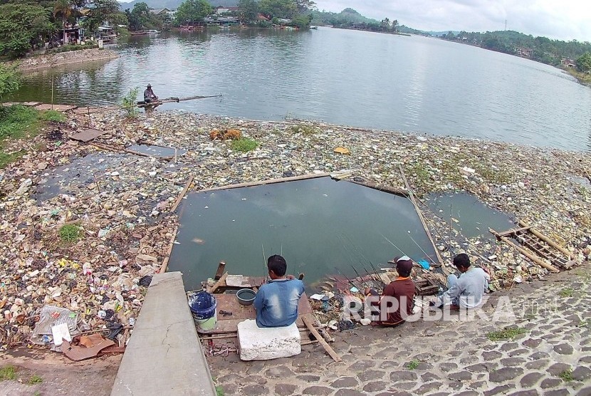 Sejumlah pemancing mengarahkan jorannya ke lubang yang sengaja mereka buat di antara sampah di pinggiran Situ Ciburuy, Padalarang, Kabupaten Bandung Barat, Senin (16/1). 