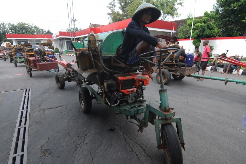 Sejumlah pemilik jasa penyedia alat pertanian membawa traktor dan mesin penggilingan padi atau tleser saat melakukan aksi protes dihentikannya layanan penjualan solar di SPBU Karangduren, Sawit, Boyolali, Jawa Tengah, Senin (28/1/2019).