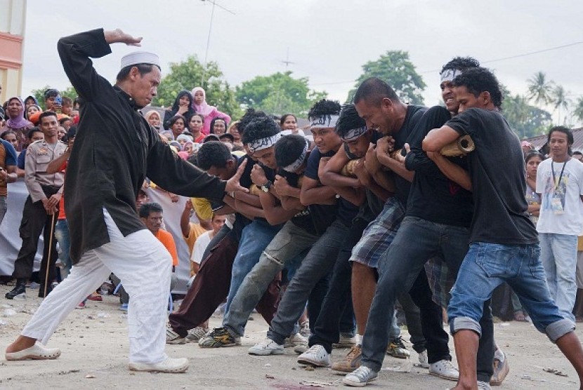 Sejumlah pemuda memainkan atraksi Bambu Gila, pada Pesta Rakyat di Negeri Tulehu, Pulau Ambon, Maluku, Jumat (26/10).