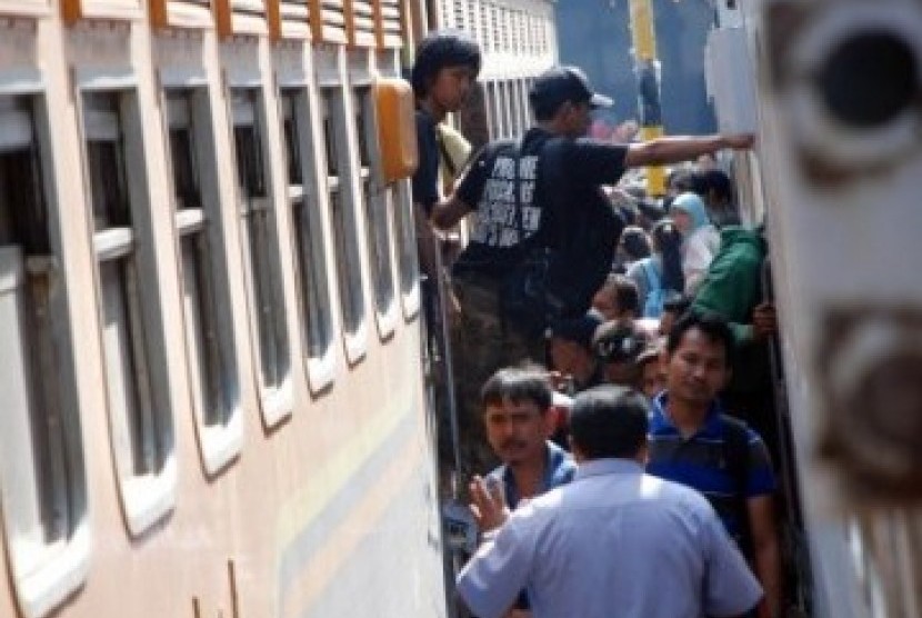 Sejumlah pemudik berebut untuk memasuki rangkaian gerbong kereta api yang akan membawa kekampung halaman di Stasiun Pasar Turi, Surabaya, Senin (29/8).