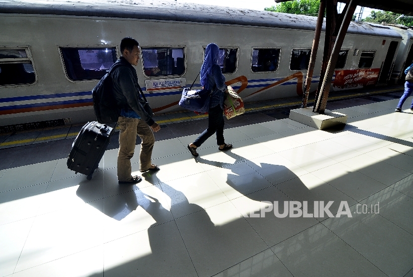 Sejumlah pemudik berjalan sekaligus membawa barangnya seusai turun dari kereta api di Stasiun Pasar Senen, Jalan Senen Raya, Jakarta Pusat, Senin (3/7).