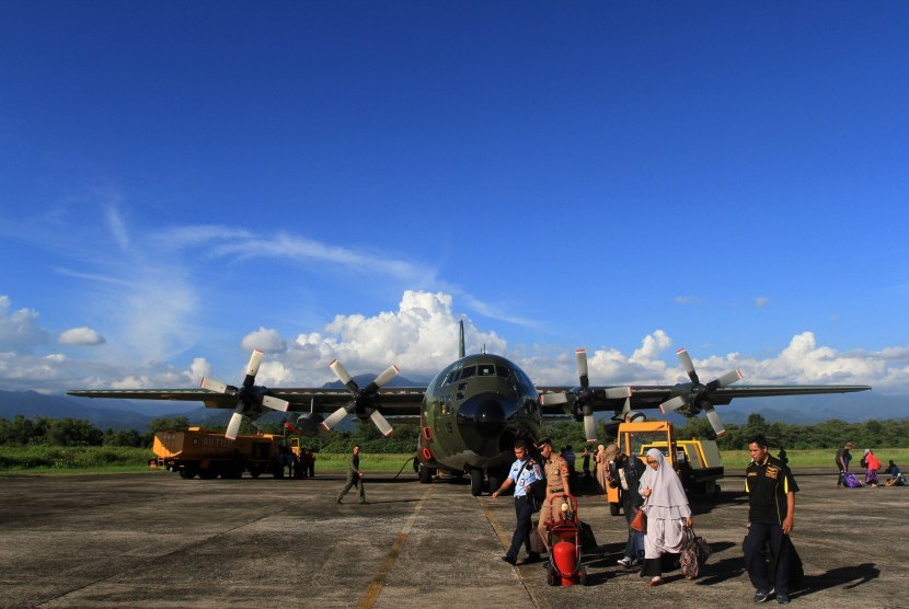 Sejumlah pemudik membawa barangnya setelah turun dari pesawat Hercules TNI AU di lapangan Udara Sultan Syharir, Padang, Sumatera Barat, Kamis (22/6). 