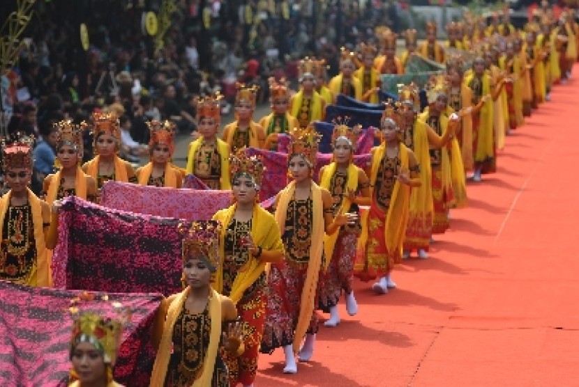 Sejumlah penari gandrung memegangi gaun Ratu Seblang saat tampil dalam Banyuwangi Ethno Carnival (BEC) di Banyuwangi, Jawa Timur, Sabtu (22/11). Acara ini merupakan bagian dari Festival Banyuwangi.