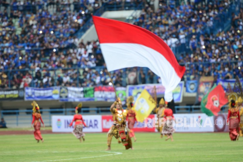 Sejumlah penari mengibarkan bendera Merah Putih dan bendera klub pada seremoni pembukaan Piala Presiden 2018 di Stadion Gelora Bandung Lautan Api, Bandung, Jawa Barat, Selasa (16/1). 