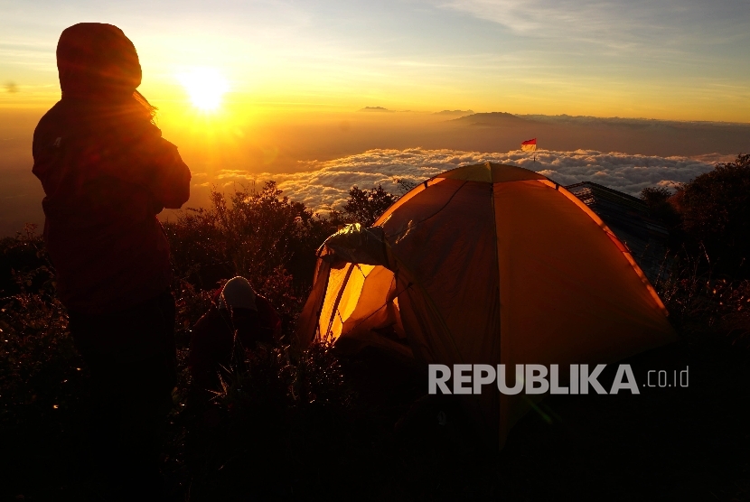 Sejumlah pendaki menikmati matahari terbit di Sendang Drajat kawasan Puncak Gunung Lawu, Perbatasan Jawa Tengah dan Jawa Timur, Jumat (19/8).