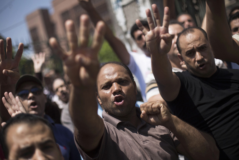  Sejumlah pendukung Presiden Muhammad Mursi meneriakkan slogan  melawan militer Mesir dalam aksi unjuk rasa di dekat masjid Al-Nour di Kairo, Jumat (23/8).   (AP/Manu Brabo)
