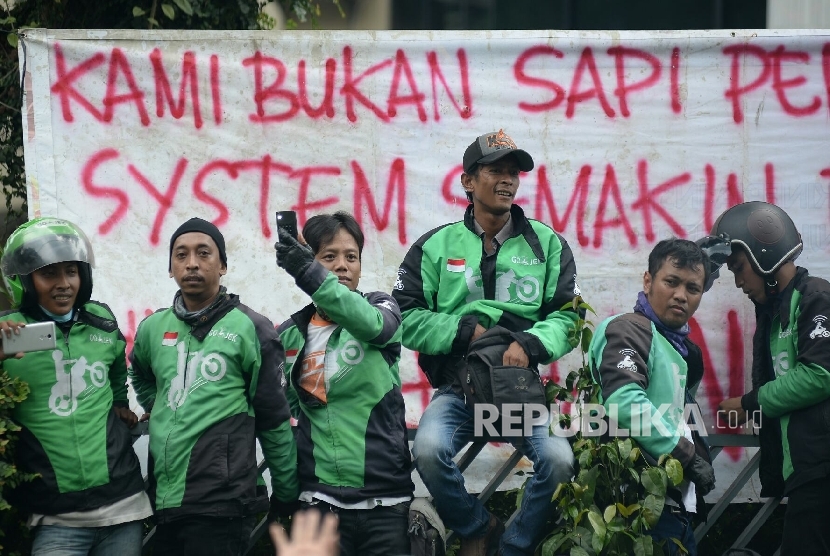 Sejumlah pengemudi Gojek menunggu hasil aksi. Selama ini sistem hubungan kerja PT Gojek Indonesia dan pengemudi adalah kemitraan.
