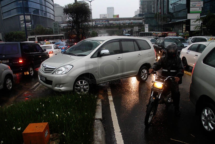   Sejumlah pengemudi kendaraan terpaksa memutar balik melewati jalur hijau saat terjebak kemacetan di Jalan MH. Thamrin, Jakarta, Jumat (21/12).   (Republika/Yasin Habibi)