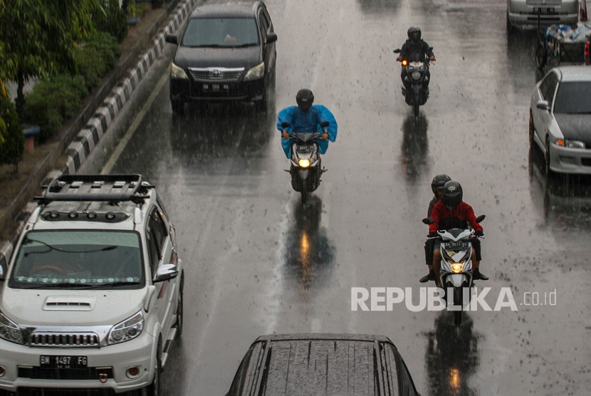 Sejumlah pengendara kendaraan bermotor melintas di Jalan Tuanku Tambusai ketika hujan mengguyur Kota Pekanbaru, Riau, Senin (26/8/2019). 