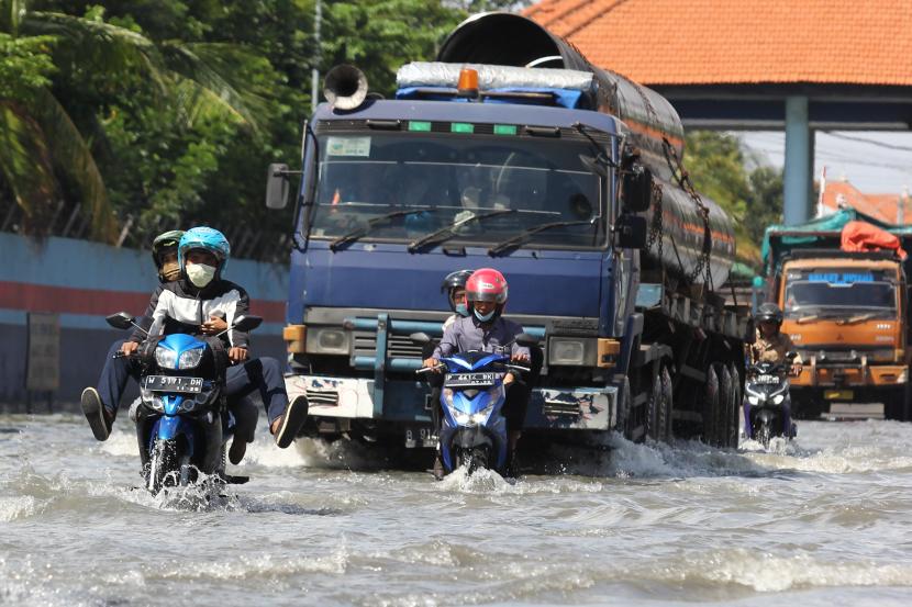 Sejumlah pengendara kendaraan bermotor melintasi banjir rob di Jalan Kalimas Baru, Surabaya, Jawa Timur   (ilustrasi)