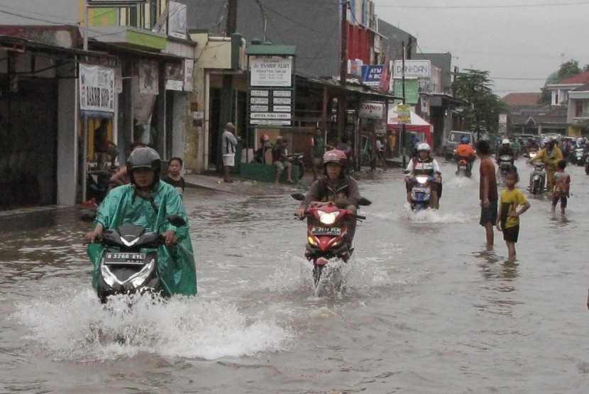 Sejumlah pengendara kendaraan bermotor mengarungi banjir di ruas jalan Nusantara Raya, Perumnas 3, Bekasi Timur, Jawa Barat, Jumat (26/2).