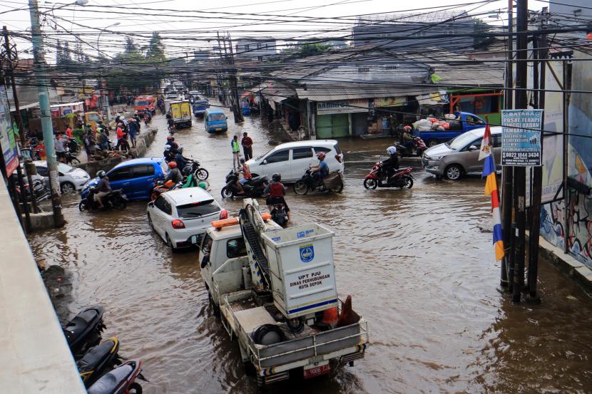 Sejumlah pengendara kendaraan menerobos genangan banjir di Jalan Raya Sawangan, Perempatan Mampang, Depok, Jawa Barat, Rabu (18/5/2022). Hujan deras yang mengguyur pada Selasa (17/5) malam hingga pagi hari membuat air sungai di sekitar lokasi meluap serta diperparah buruknya sistem drainase menyebabkan banjir dengan ketinggian sekitar 50 cm.