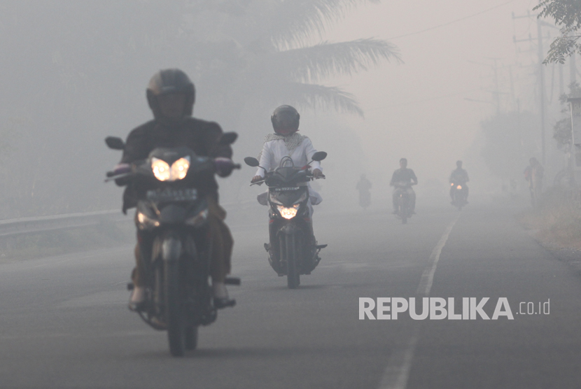 Sejumlah pengendara melaju di jalan yang dipenuhi kabut asap di Jalan Medan - Banda Aceh di Desa Suak Raya, Kecamatan Johan Pahlawan, Aceh Barat, Aceh, Senin (24/7). 