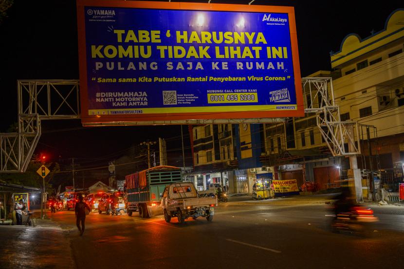 Sejumlah pengendara melintas di bawah baliho berisi imbauan untuk berada di rumah saja di salah satu ruas jalan di Palu, Sulawesi Tengah, Minggu (29/3/2020). Pemerintah setempat terus mengimbau warga dengan berbagai cara untuk berada di rumah saja guna meminimalisir penyebaran Virus Corona.