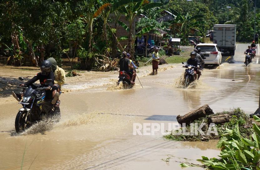 Sejumlah pengendara melintasi banjir di jalan trans Sulawesi di Kabupaten Mamuju (ilustrasi)