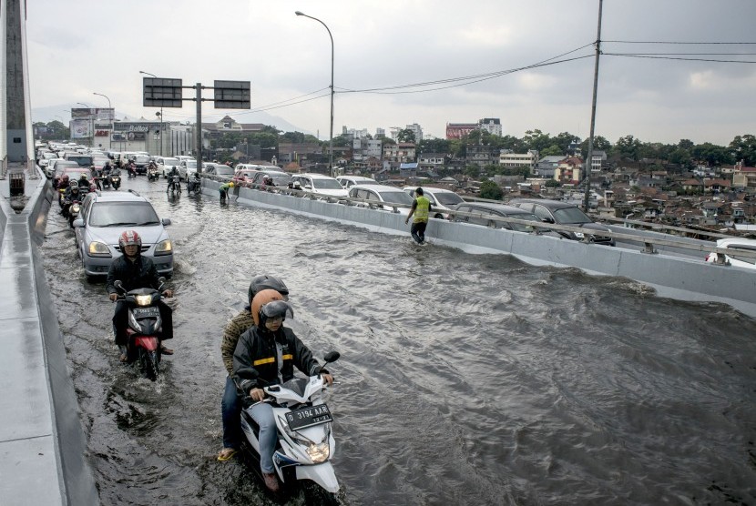 Sejumlah pengendara melintasi genangan banjir di Jembatan Layang Pasopati Bandung, Jawa Barat, Jumat (29/9). 