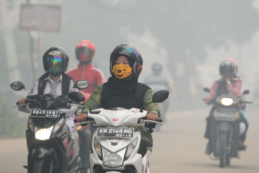 Sejumlah pengendara melintasi jalan yang diselimuti kabut asap di Jalan Tanjung Raya, Pontianak, Kalbar, Rabu (16/9). 