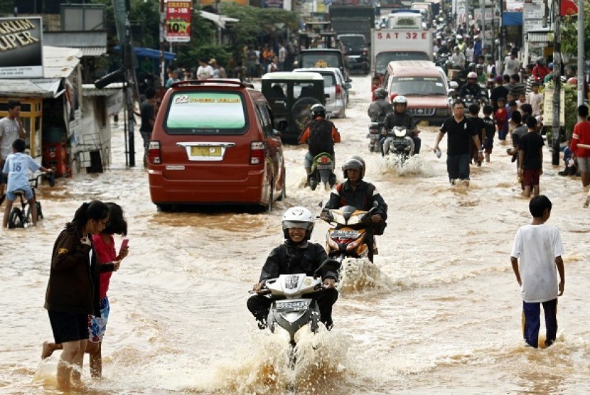 Sejumlah pengendara menerabas banjir yang memutus jalan Raya Jati Kramat, Jatiasih, Bekasi, Jawa Barat, Rabu (17/4). Meluapnya air Kali Bekasi menyebabkan terputusnya Jalan Raya Jati Kramat di sekitar perumahan Bumi Nasio Indah.