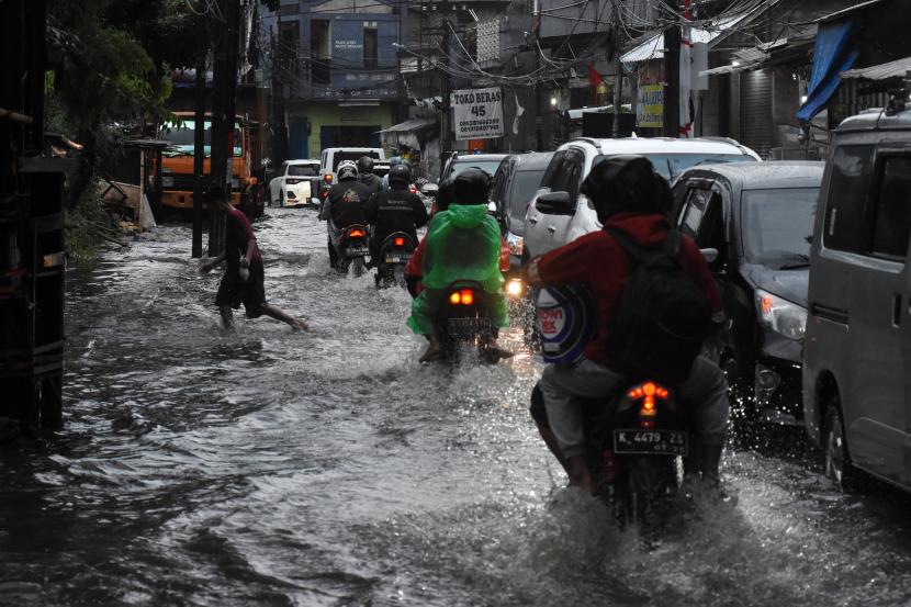 Sejumlah pengendara menerobos banjir di kawasan Pasar Warung Buncit, Jakarta Selatan, Sabtu (15/10/2022). Kawasan tersebut kerap menjadi langganan banjir saat hujan deras yang disebabkan sistem drainase yang kurang maksimal dan aliran Kali Mampang yang mengalami pendangkalan. 