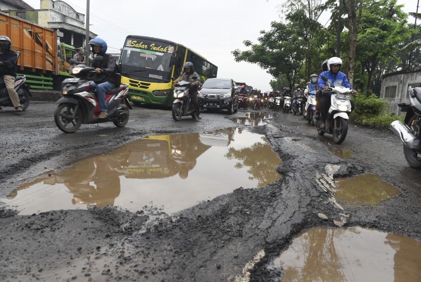 Sejumlah pengendara menghindari jalan yang rusak di wilayah Kraton, Kabupaten Pasuruan, Jawa Timur, Senin (16/1).