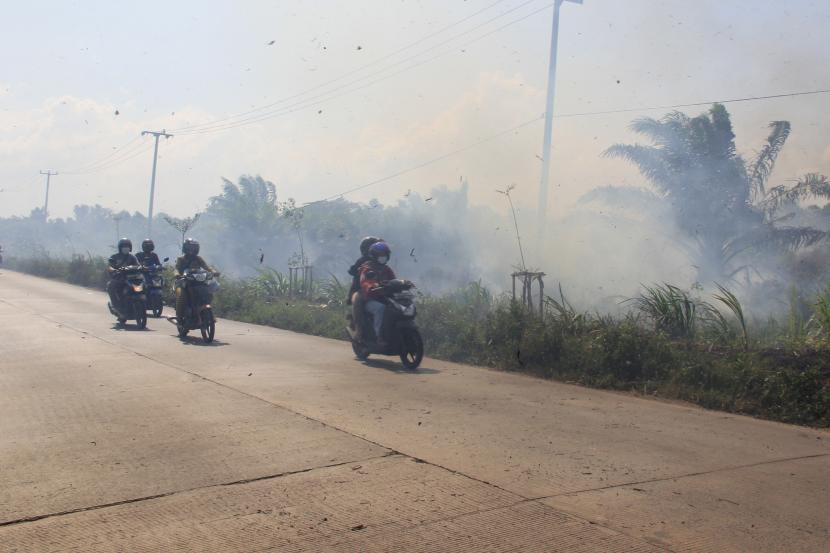 Pengendara motor melintas di jalan yang diselimuti kabut asap kebakaran lahan, di Kelurahan Tanjung Palas Dumai, Riau, Jumat (26/2/2021). Kebakaran lahan kembali terjadi, Sabtu (23/3/2024).
