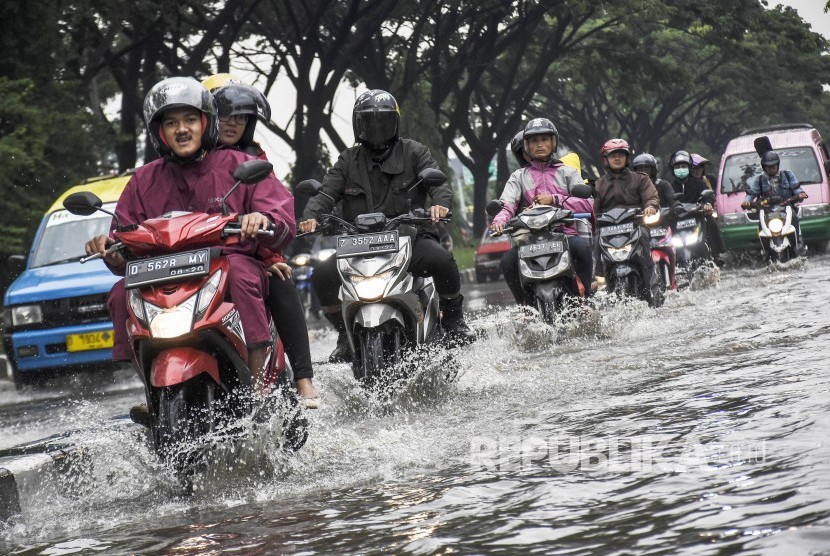 Sejumlah pengendara motor melintasi banjir di ruas Jalan Soekarno Hatta, Gedebage, Kota Bandung, Rabu (25/12).