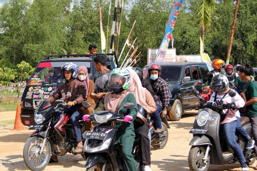 Sejumlah pengendara motor memasuki lokasi wisata pantai Koneng pada hari kedua Lebaran di Dumai, Riau, Jumat (14/5/2021). Obyek wisata pantai Dumai ramai dikunjungi warga pada hari kedua Lebaran yang datang dari luar daerah seperti Bengkalis, Rokan Hilir dan Pekanbaru meskipun ada larangan membuka tempat wisata oleh Polda Riau.