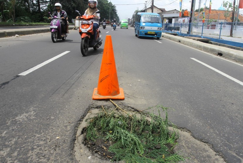 Sejumlah pengendara saat melintasi jalan yang berlubang di Jalan Raya Bogor, Nanggewer, Kabupaten Bogor, Jawa Barat, Rabu (23/3).
