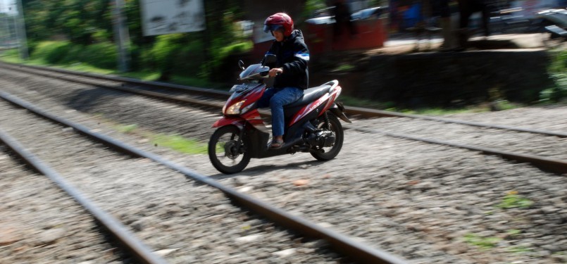 Sejumlah pengendara sepeda motor melintasi perlintasan rel kereta api tanpa palang pintu di Palmerah, Jakarta, Rabu (21/3). (Republika/Agung Fatma Putra)