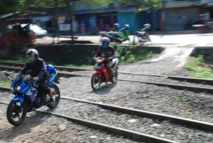 Sejumlah pengendara sepeda motor melintasi perlintasan rel kereta api tanpa palang pintu. ilustrasi (Dok Republika)