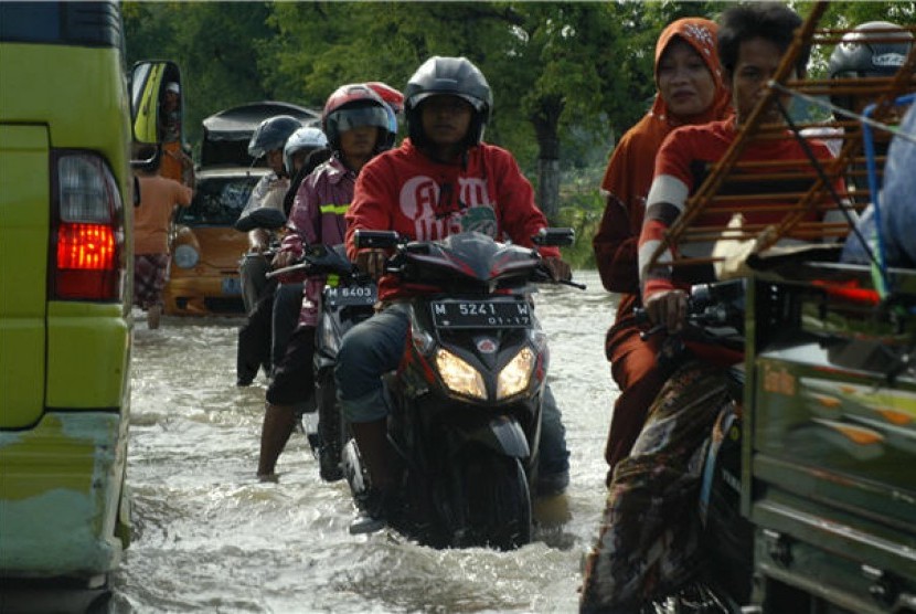 Sejumlah pengendara sepeda motor menerobos genangan banjir. (ilustrasi) 