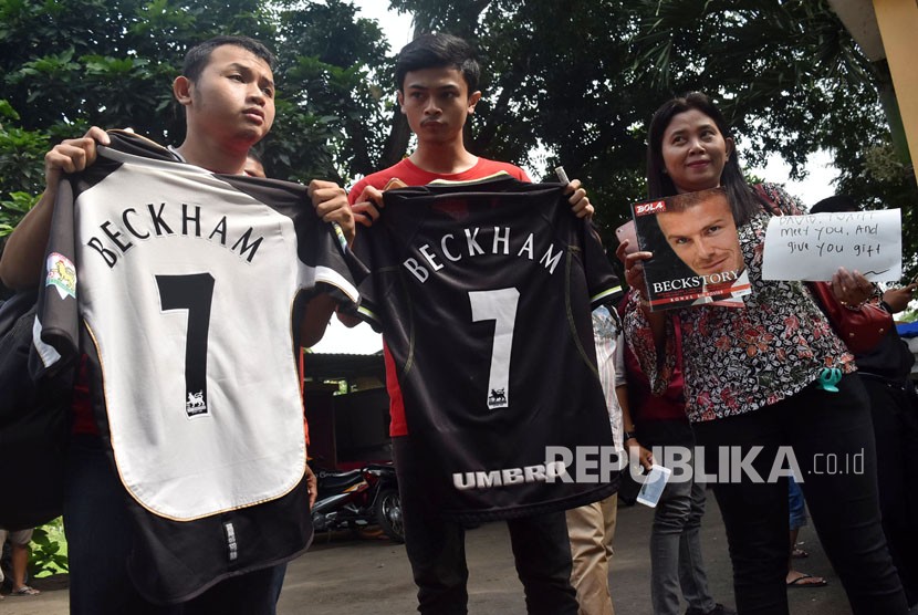 Sejumlah penggemar mantan pesepakbola asal Inggris, David Beckham membentangkan kaos sepakbola dan poster saat menanti idolanya keluar usai mengisi acara di SMP 33 Semarang, Jawa Tengah, Rabu (28/3). 