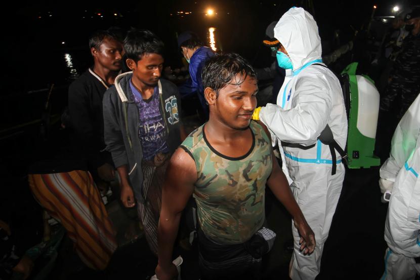 Sejumlah pengungsi etnis Rohingya berjalan menuju bus saat proses evakuasi di Pelabuhan ASEAN, Krueng Geukuh, Aceh Utara, Aceh, Jumat (31/12/2021). Pemerintah Indonesia melalui Satgas Penanganan Pengungsi Luar Negeri (PPLN) mempertimbangkan keadaan darurat dan sisi kemanusiaan sehingga memutuskan untuk menyelamatkan 120 orang etnis Rohingya terdiri dari tujuh laki-laki, 62 perempuan dan 51 anak-anak yang terdampar di perairan laut Aceh pada Sabtu (25/12/2021).