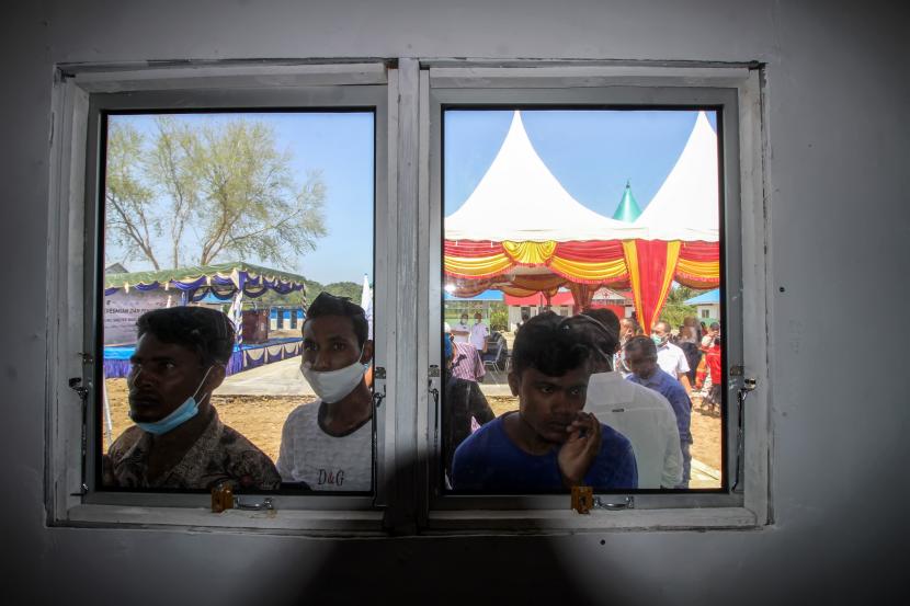 Sejumlah pengungsi etnis Rohingya melihat tempat perlindungan (shelter)  di Desa Meunasah Mee, Lhokseumawe, Aceh, Rabu (24/2/2021). UNHCR meresmikan sebanyak 30 unit shelter baru dengan fasilitas satu unit ruang belajar, 28 unit toilet, lima unit tempat cuci, satu unit dapur umum, lapangan bola voli dan takraw untuk ditempati 108 orang sisa pengungsi Rohingya di Aceh.
