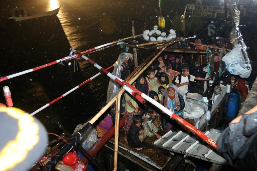 Sejumlah pengungsi etnis Rohingya menunggu di atas perahunya sebelum proses evakuasi di Pelabuhan ASEAN, Krueng Geukuh, Aceh Utara, Aceh, Jumat (31/12/2021). Pemerintah Indonesia melalui Satgas Penanganan Pengungsi Luar Negeri (PPLN) mempertimbangkan keadaan darurat dan sisi kemanusiaan sehingga memutuskan untuk menyelamatkan 120 orang etnis Rohingya terdiri dari tujuh laki-laki, 62 perempuan dan 51 anak-anak yang terdampar di perairan laut Aceh pada Sabtu (25/12/2021). 
