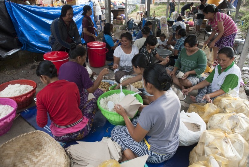 Sejumlah pengungsi Gunung Agung terlibat dalam dapur umum untuk mengisi waktu mereka selama di penampungan di Desa Manggis, Karangasem, Bali, Selasa (26/9). 