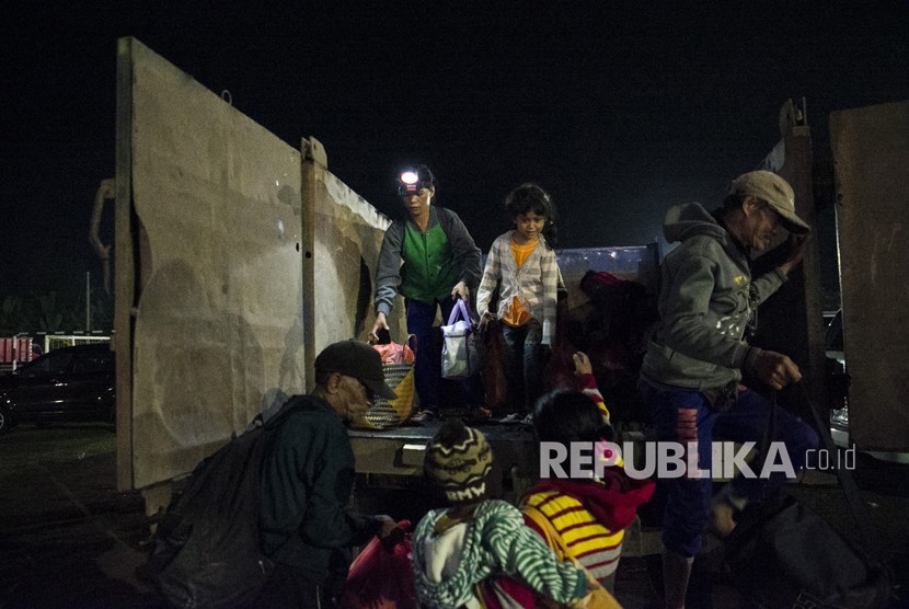 Sejumlah pengungsi Gunung Agung turun dari truk setibanya di tempat penampungan GOR Suwecapura, di Klungkung, Bali, Selasa (21/11). 