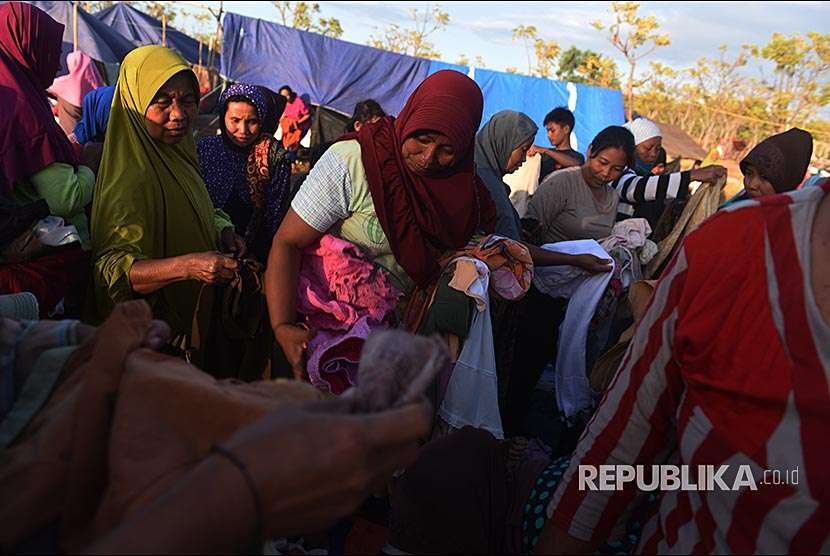 Sejumlah pengungsi korban gempa bumi memilih pakaian bekas di tempat pengungsian di Desa Santong, Kayangan, Lombok Utara, NTB, Sabtu (11/8). 