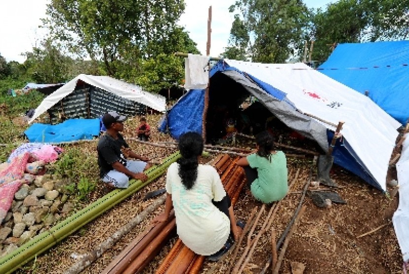 Sejumlah pengungsi korban gempa bumi memperbaiki tenda yang ditempatinya di lokasi pengungsian Desa Waai, Pulau Ambon, Kecamatan Salahutu, Kabupaten Maluku Tengah, Sabtu (5/10). Para pengungsi tersebut mengungsi ke hutan dan menempati tenda-tenda yang dibangun sendiri pascagempa yang mengguncang Pulau Ambon dan sekitarnya, Kamis (26/9). 