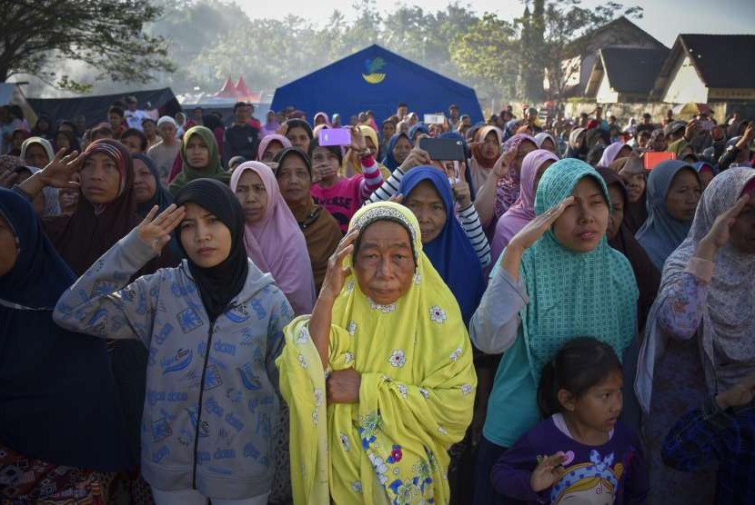 Sejumlah pengungsi korban gempa bumi mengikuti apel bendera peringatan HUT ke-73 RI di Posko Pengungsian Gunungsari, Lombok Barat, NTB, Jumat (17/8). 