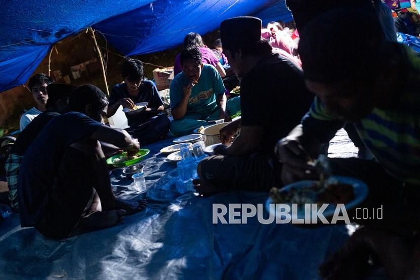 Sejumlah pengungsi korban gempa makan malam di tenda darurat yang mereka buat 