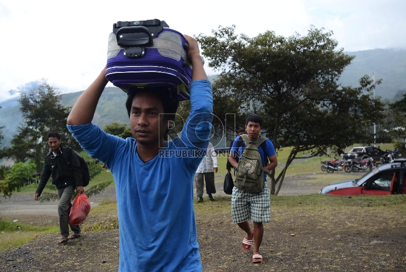 Sejumlah pengungsi korban kebakaran kios memindahkan barangnya menuju Kantor Bupati untuk kemudian ditempati di Tolikara, Papua, Jumat (24/7). 