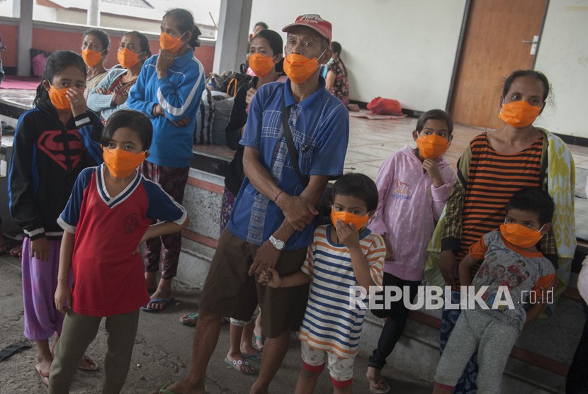 Sejumlah pengungsi mengenakan masker setelah terjadi hujan abu letusan Gunung Agung, di lokasi penampungan Desa Bebandem, Karangasem, Bali, Ahad (26/11). 