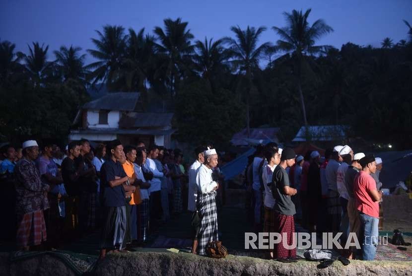  Sejumlah pengungsi menunaikan salat Maghrib di tempat penampungan pengungsi korban gempa bumi di Pemenang, Lombok Utara, Lombok Utara, NTB, Selasa (7/8).