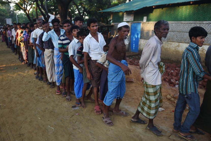 Sejumlah pengungsi Rohingya antri untuk mendapatkan paket makanan dari relawan Indonesia di Kamp Pengungsian Kutupalong, Cox Bazar, Bangladesh, Minggu (1/10). 