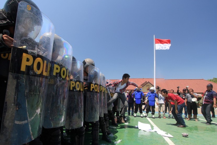 Sejumlah pengunjuk rasa berusaha menerobos barikade anggota kepolisian pada simulasi pengamanan di Polres Indramayu, Jawa Barat, Senin (18/8). 