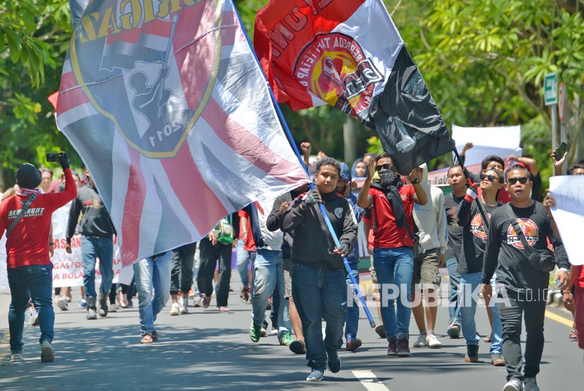 Sejumlah pengunjuk rasa gabungan suporter Indonesia melakukan long march ke lokasi Kongres PSSI 2019 berlangsung, di Nusa Dua, Bali, Ahad (20/1/2019). 